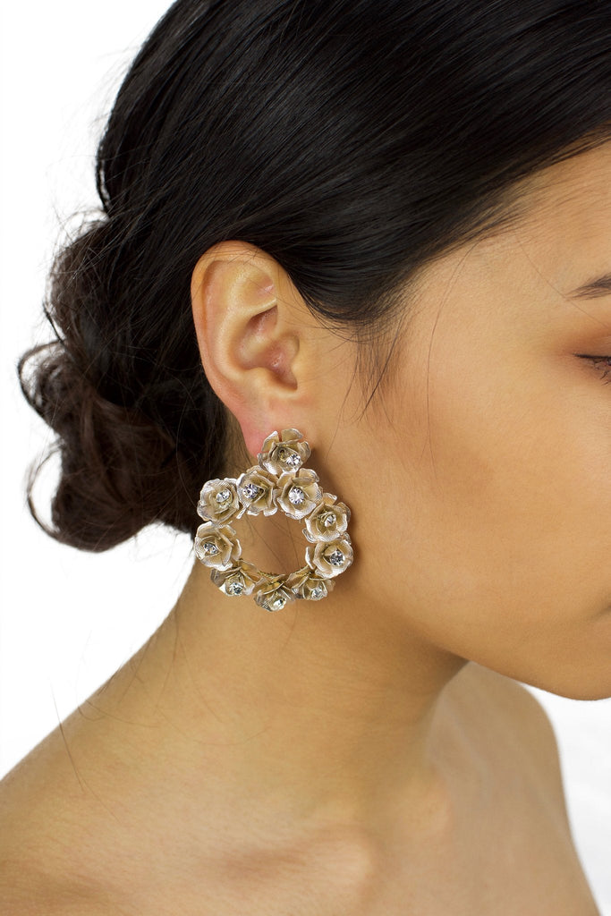 Ring of pale gold flowers earring worn by a bride with up style hair