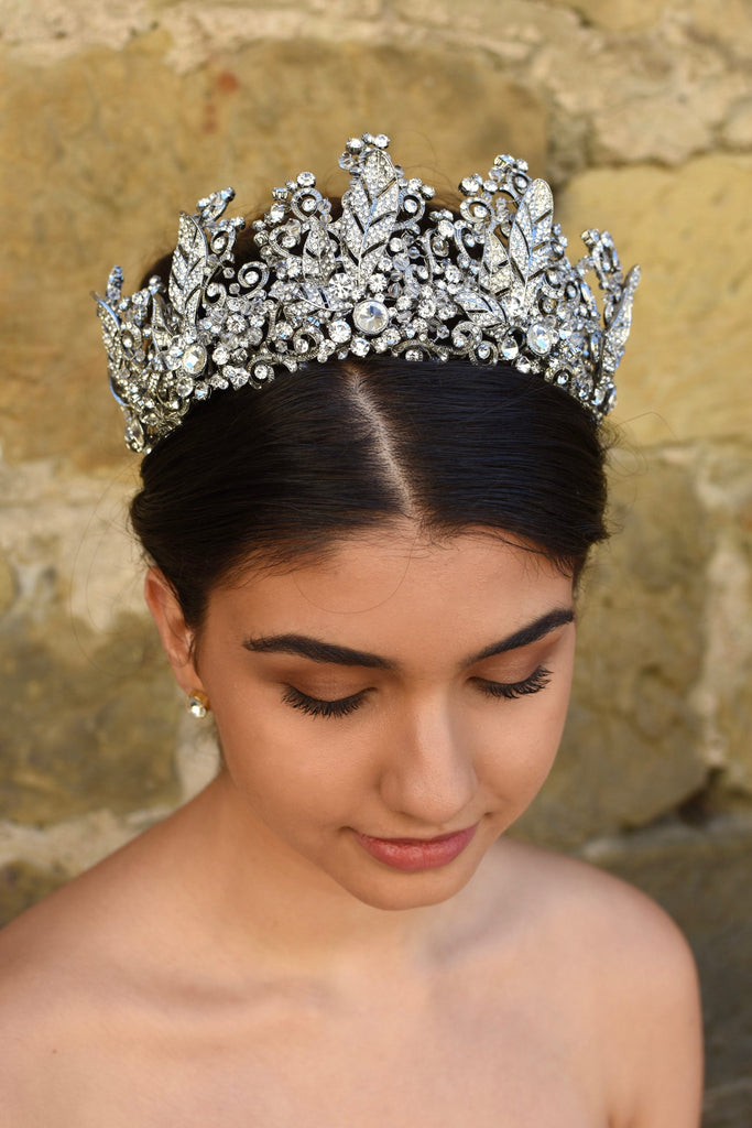 A high many points crown worn by a dark hair model with an old sandstone wall backdrop