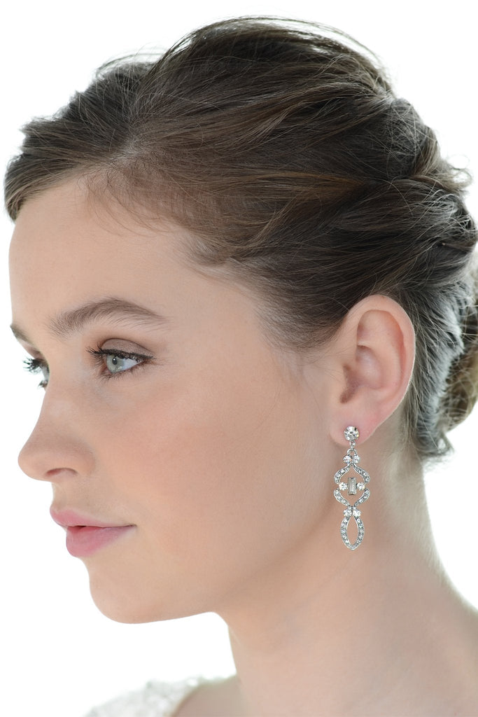 Beautiful short brown hair bride wearing a mid length drop earring with a white background