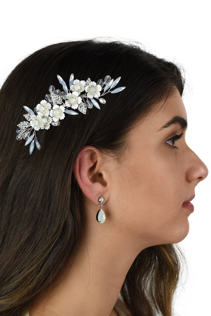 Dark Haired model wears a small silver comb with white opal stones against a white background