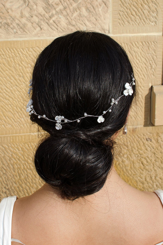 Single Strand Silver wire pearl vine worn at the back of a brides head shown with a stone wall behind