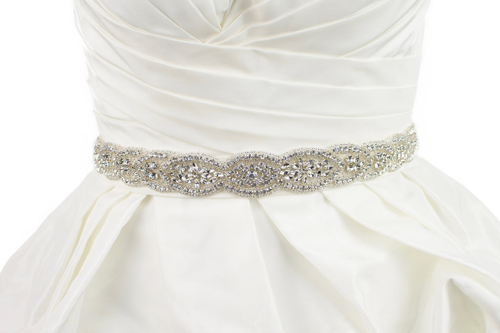 Silver Bridal belt full of shining stones worn on an ivory bridal gown with a white background