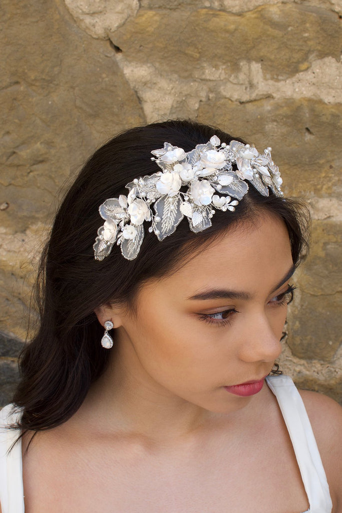 Black hair Bride wearing a lace and flower headband in front  of a stone wall