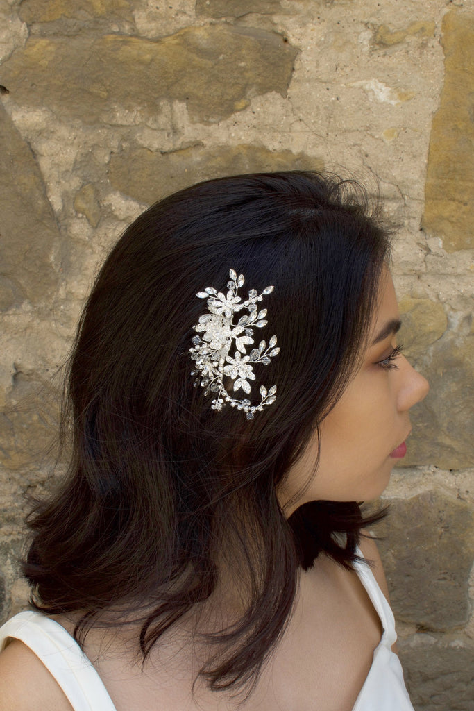 Silver Leaves and Crystals side comb worn by a dark haired model with a stone wall background