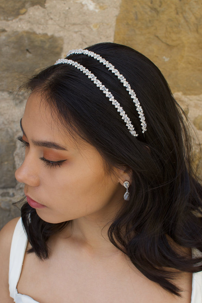 Dark hair model wears a two row bridal headband with a sandstone wall behind