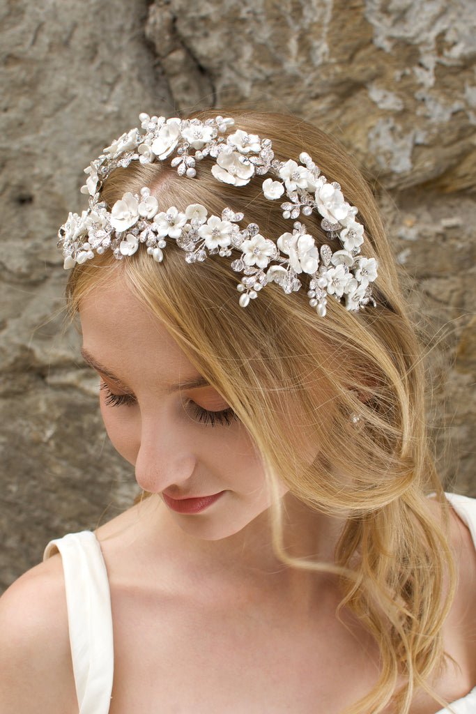 Blonde bride wears a double row flower headband with a stone wall background