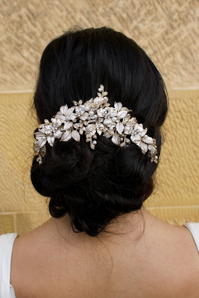 A Thick Pale Gold Short Bridal Vine on a dark hair model at the back of the head with a sandstone backdrop